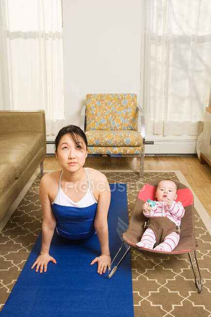 Una madre che pratica yoga — Foto stock