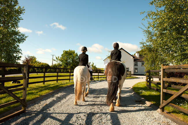 Ragazzi a cavallo insieme, vista posteriore — Foto stock