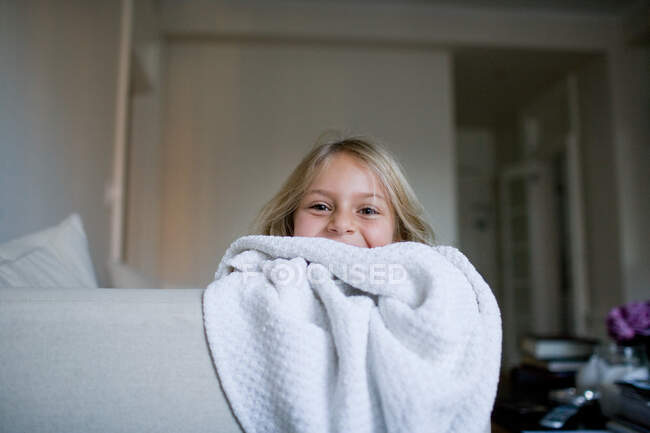 Girl peeking over blanket — Stock Photo