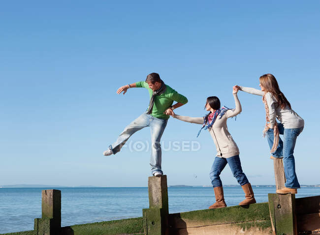 People balancing on jetty — Stock Photo
