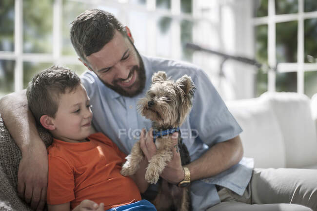 Città del Capo, Sud Africa, padre e figlio che giocano con il cucciolo, in una casa moderna — Foto stock
