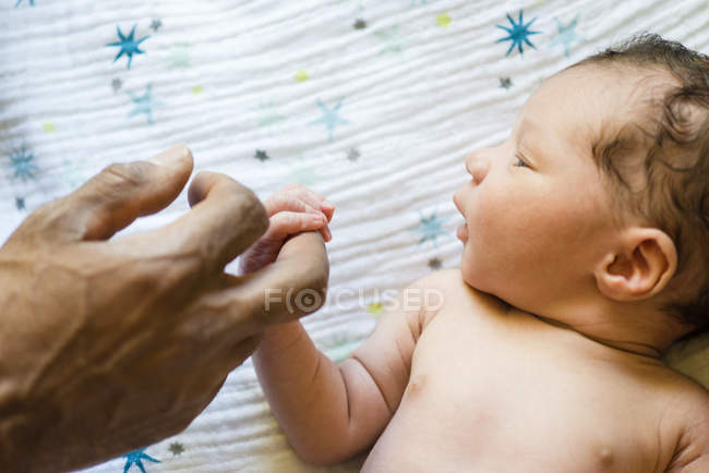Padre sosteniendo durmiendo bebé niños mano - foto de stock
