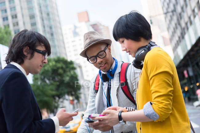 Three friends on street with mp3 player — Stock Photo