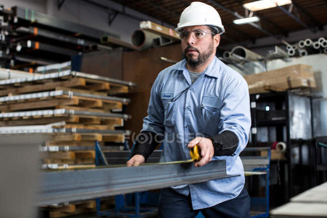 Worker measuring in metal plant — Stock Photo