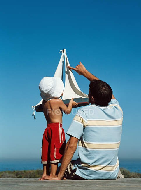 Батько і син з іграшковим човном — стокове фото