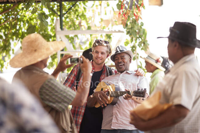 Kapstadt, Südafrika, Mann spielt Gitarre und Leute auf dem Markt fotografieren — Stockfoto