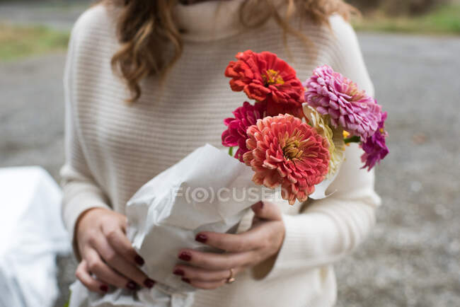Section du milieu de la femme tenant un bouquet de fleurs à la boutique de ferme biologique — Photo de stock