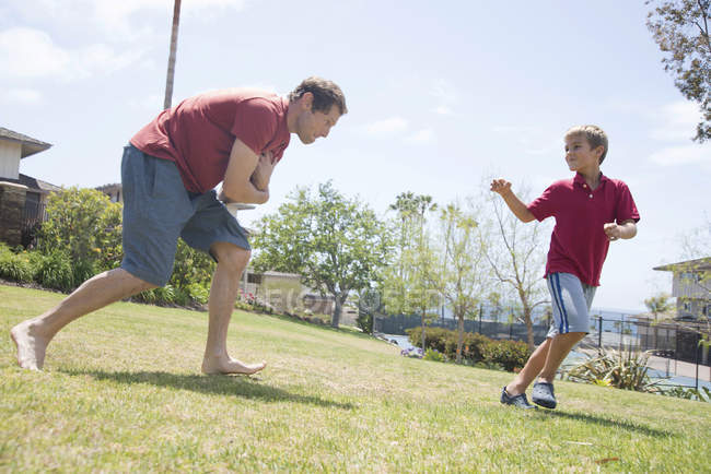 Padre e figlio che praticano il calcio americano nel parco — Foto stock