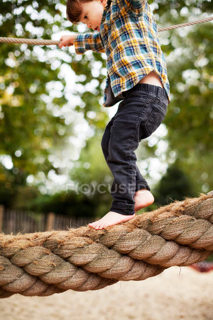 Male toddler crossing rope bridge — Stock Photo