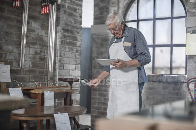 Cape Town, South Africa, elderly craftsman in workshop on pad — Stock Photo