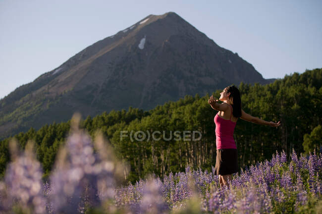 Жінка стоїть на полі квітів — стокове фото