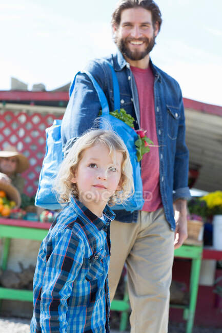 Отец и сын на фермерском рынке — стоковое фото
