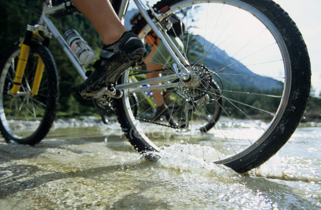 People cycling across a stream — Stock Photo