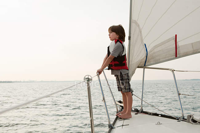 Молодий хлопчик на борту яхти, дивлячись на вид — стокове фото