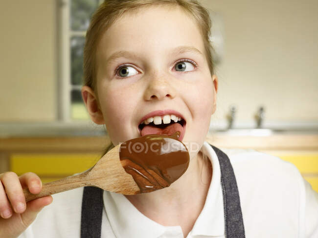 A girl licks a spoon — Stock Photo