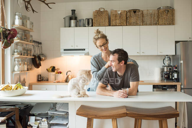 Casal com gato no balcão da cozinha — Fotografia de Stock