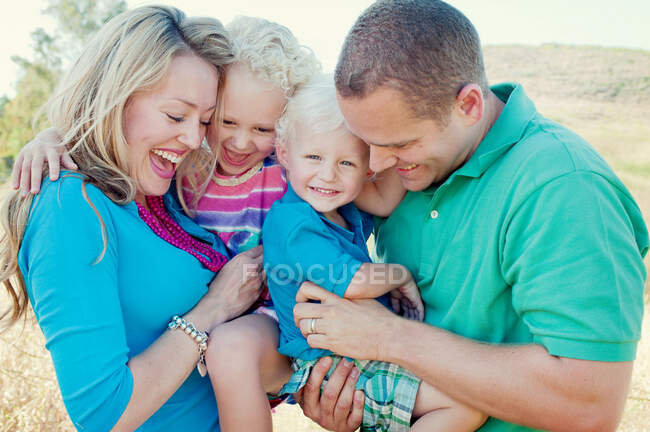 Retrato de família com duas crianças rindo — Fotografia de Stock