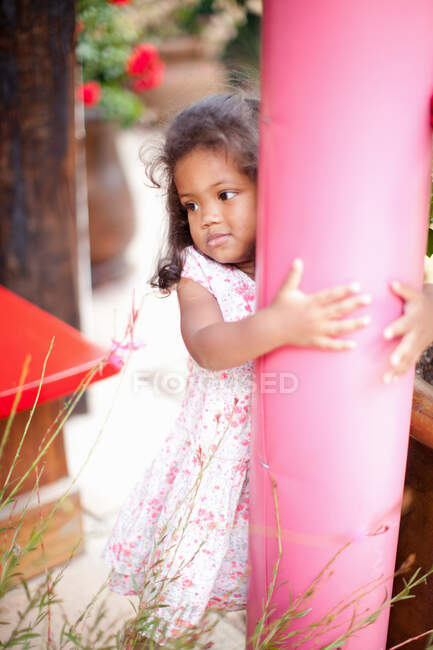 Girl hugging pole outdoors — Stock Photo