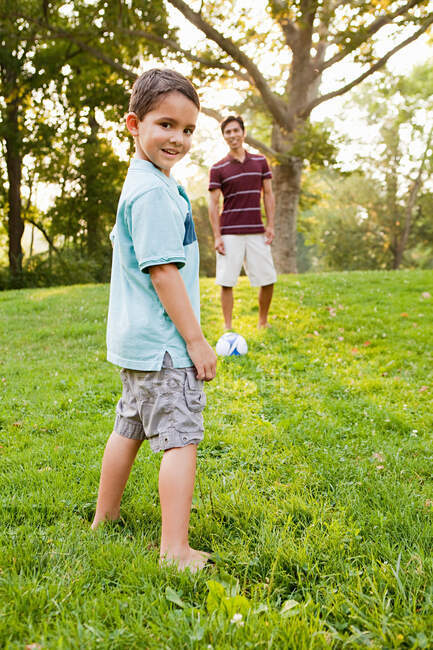 Хлопчик в парку з батьком, посміхаючись — стокове фото