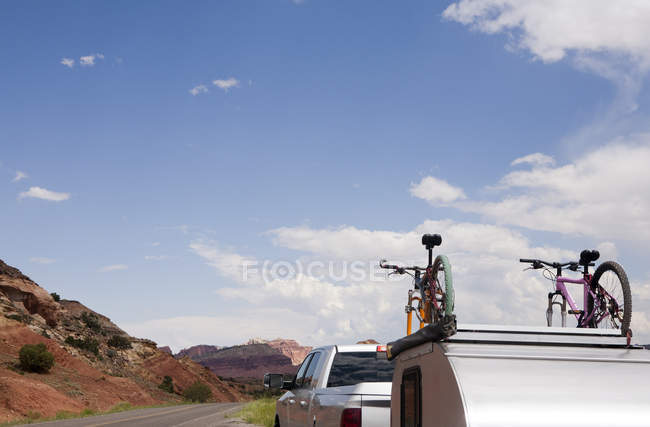 Camión con bicicletas y remolque bajo el cielo azul - foto de stock