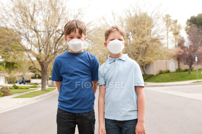 Dos chicos con máscaras antipolvo - foto de stock