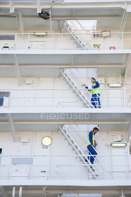 Two workers walking up and down stairs — Stock Photo