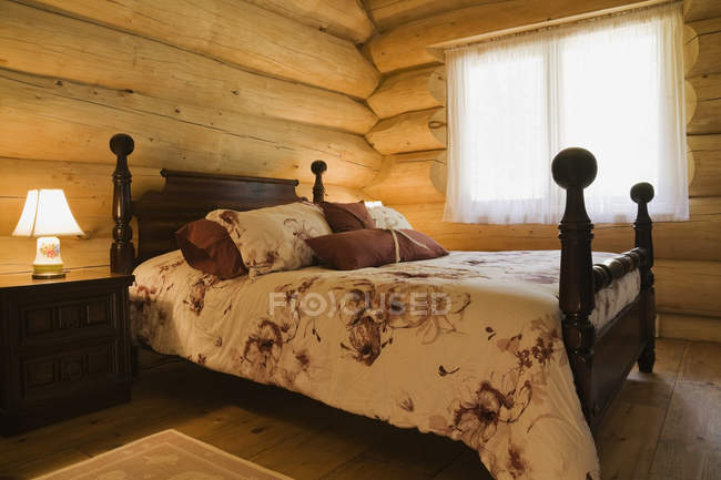 Vista inclinada da cama de madeira antiga na cabine de madeira branca oriental — Fotografia de Stock