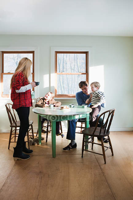 Famille prenant le petit déjeuner à la maison ensemble — Photo de stock