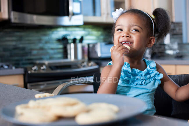Young girl eating biscuits — Stock Photo