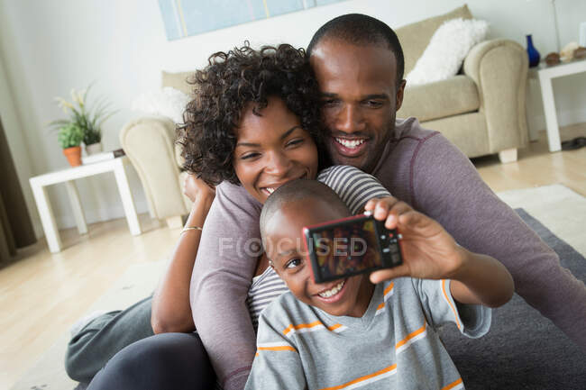 Родители и сын фотографируются с цифровой камерой — стоковое фото