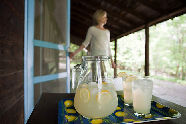 Tray of lemonade, woman in background — Stock Photo