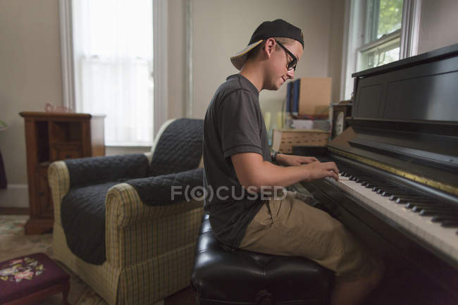 Porträt eines halbwüchsigen Jungen, der zu Hause Klavier spielt — Stockfoto