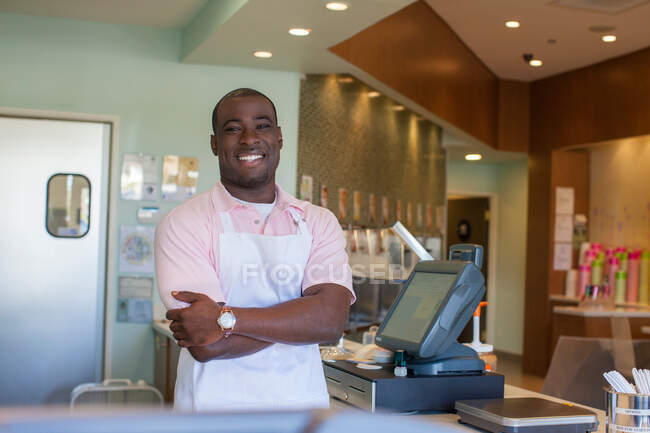 Cashier smiling behind counter — Stock Photo