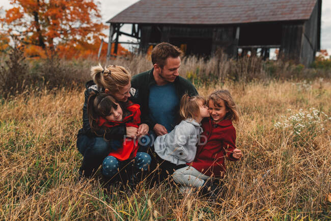 Mid adult family with three daughters together in rural field — Stock Photo