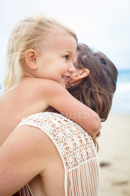 Girl hugging mother tightly around neck — Stock Photo
