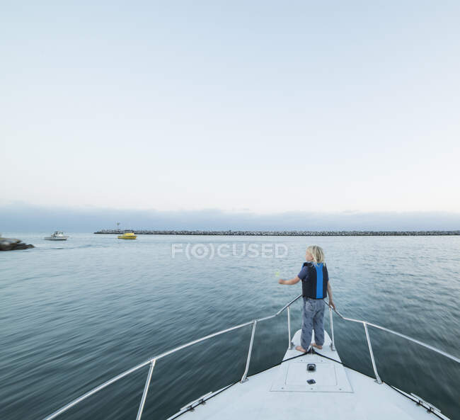 Задній вигляд хлопчика на носі човна, Дана Пойнт, Каліфорнія, США — стокове фото