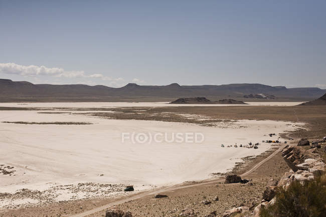 Salinas con vista lejana de campistas y vehículos todoterreno, Ibex, Utah, EE.UU. - foto de stock