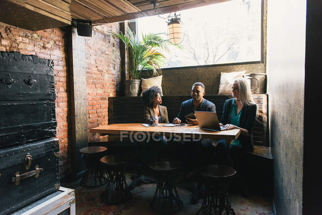 Colegas sentados à mesa em reunião no café — Fotografia de Stock
