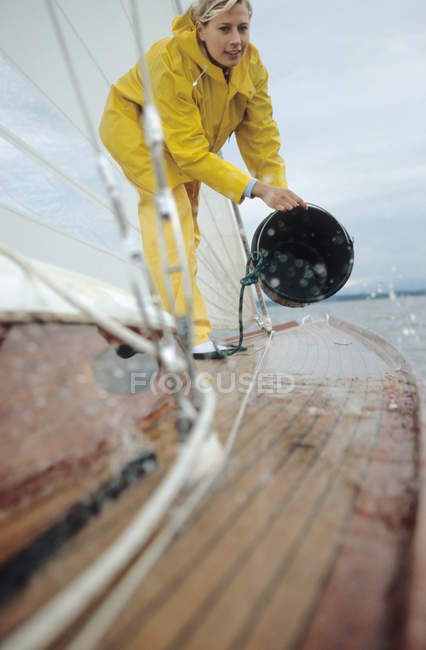 Woman washing deck of boat — Stock Photo
