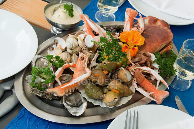 Meeresfrüchteplatte mit Kräutern auf dem Tisch — Stockfoto