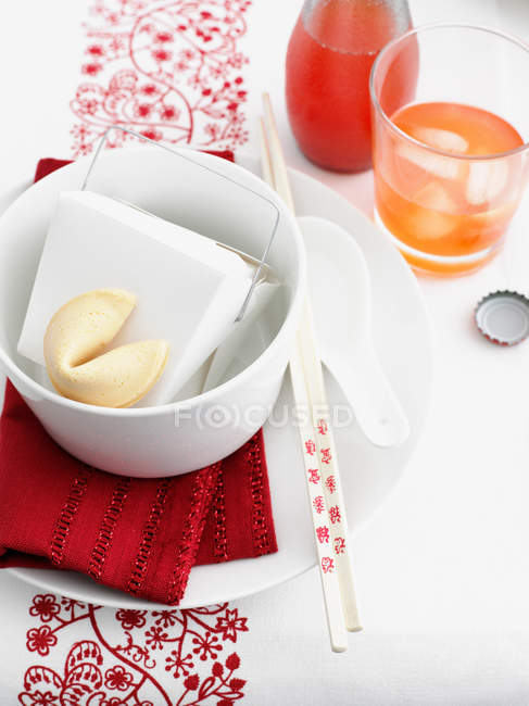 Food in Chinese take out box and glass of juice with ice cubes — Stock Photo