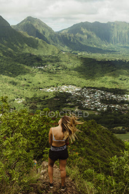 Vista trasera de la mujer en la montaña cubierta de hierba, Oahu, Hawaii, EE.UU. - foto de stock