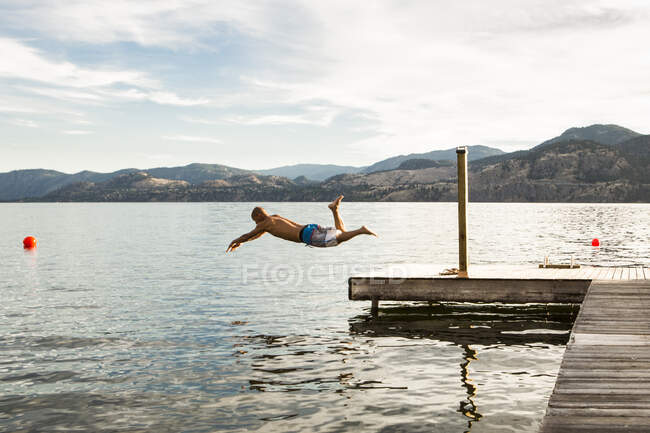 El hombre se sumerge en el lago Penticton, Canadá. - foto de stock