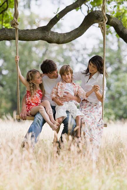 Family on a swing — Stock Photo