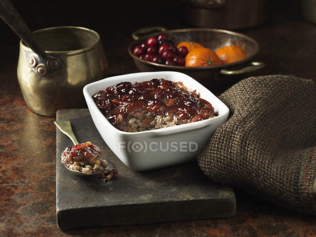 Roasted pork with cranberry and mandarin stuffing on rustic chopping board — Stock Photo