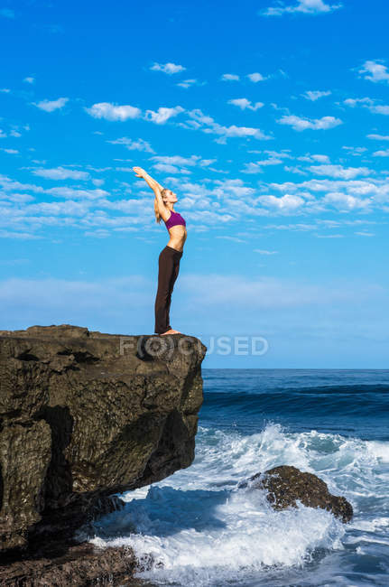Femme faisant du yoga à la côte — Photo de stock