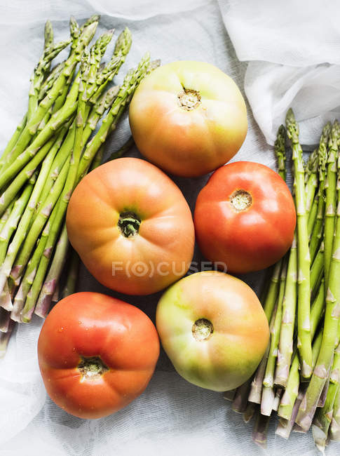 Bodegón de espárragos frescos y tomates - foto de stock