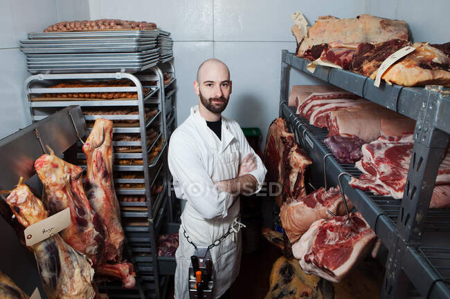 Carnicero en zona de almacenamiento de carne - foto de stock