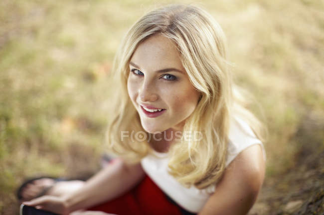 Retrato de una joven sentada en el parque - foto de stock