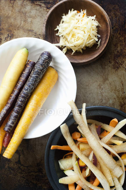 Top view of sliced and whole carrots in bowls — Stock Photo